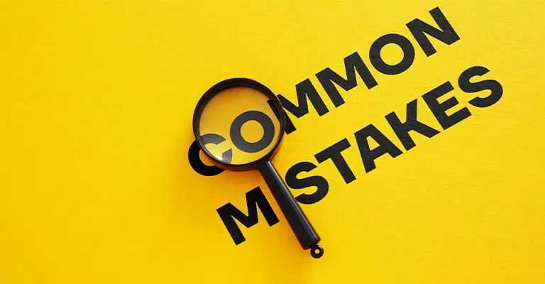 Black text reading “COMMON MISTAKES” is printed on a bright yellow background, with a magnifying glass placed over the word “COMMON” to emphasize scrutiny. The image conveys the idea of closely examining frequent errors.