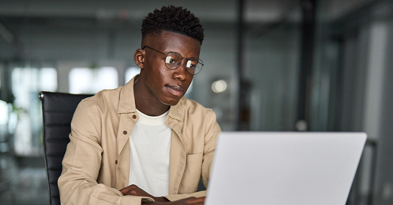 Focused student working on a laptop in a modern, well-lit setting, reflecting dedication, concentration, and building a strong digital presence.