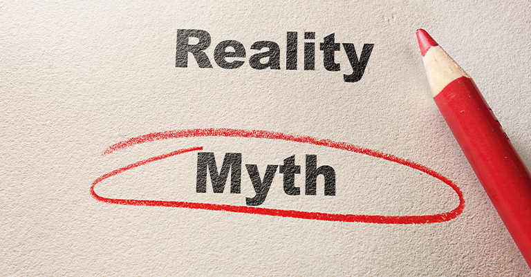 A red pencil circles the word “Myth” below the word “Reality” on textured paper, symbolizing confusion or challenge in distinguishing facts.