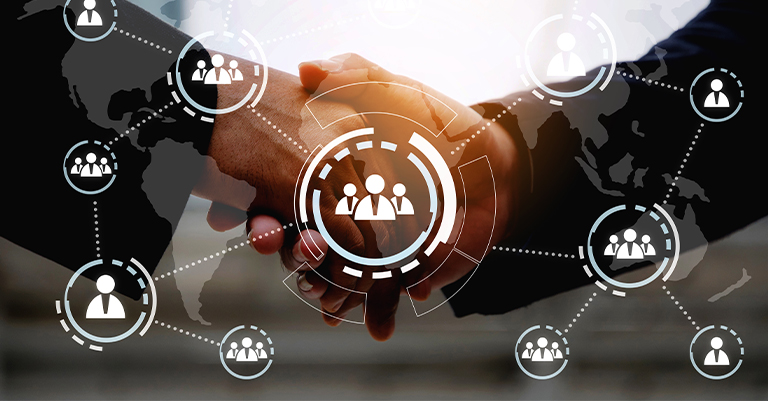 Business handshake with digital world map and icons showing global networking and people connections overlaying the image.