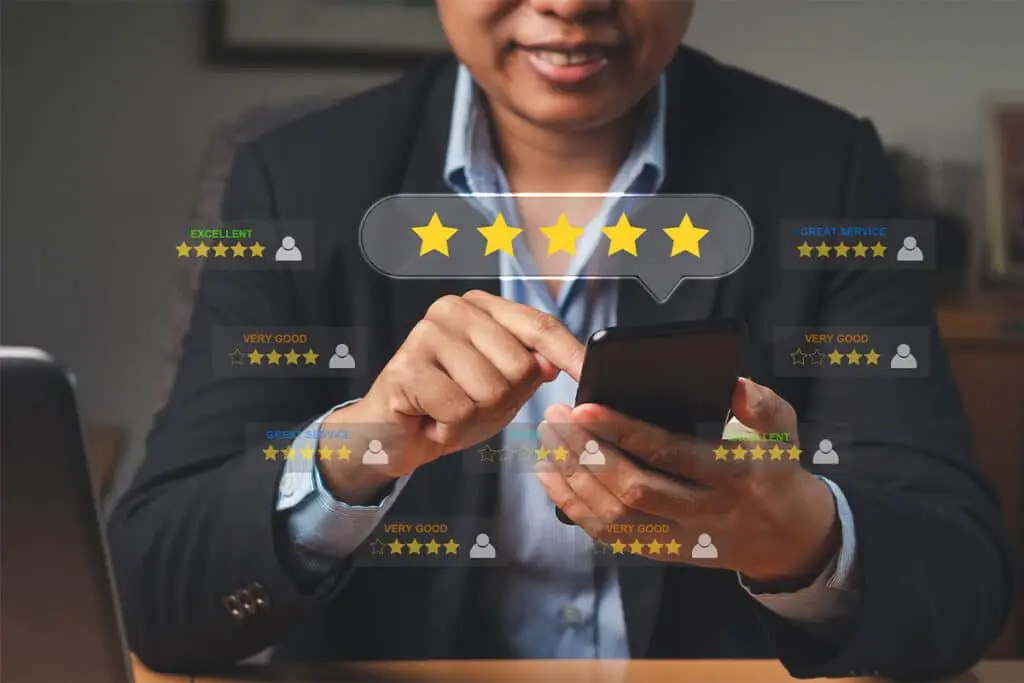 A business professional uses a smartphone while a five star rating graphic and review labels like Excellent and Great Service float on screen. The image highlights online reviews and customer feedback that help build a positive professional online reputation.