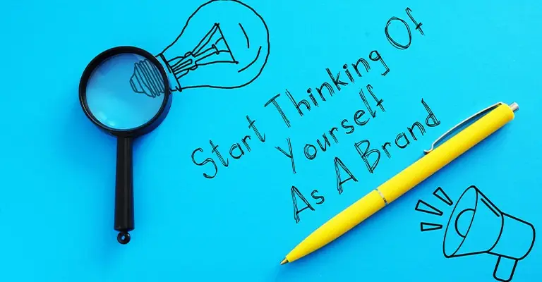 Magnifying glass and yellow pen on a bright blue background with sketches of a light bulb and megaphone. Handwritten text reads “Start Thinking Of Yourself As A Brand.”