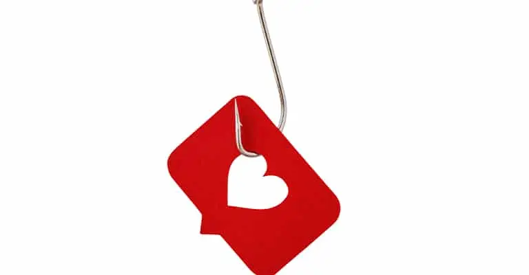 A metal fishing hook catches a red notification symbol with a white heart against a plain white background. The concept warns against chasing likes and superficial engagement while trying to build your brand on LinkedIn.