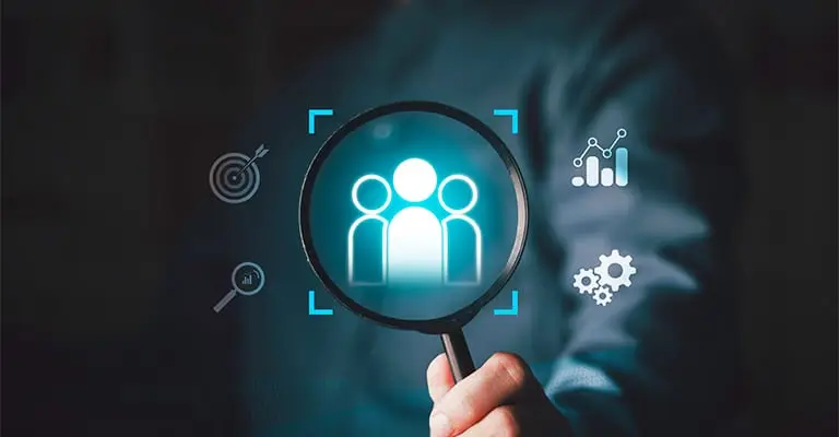A hand holds a magnifying glass over three glowing employee icons on a dark digital interface. Surrounding target. analytics. search. and gear symbols represent talent identification and skill development for early career advancement.