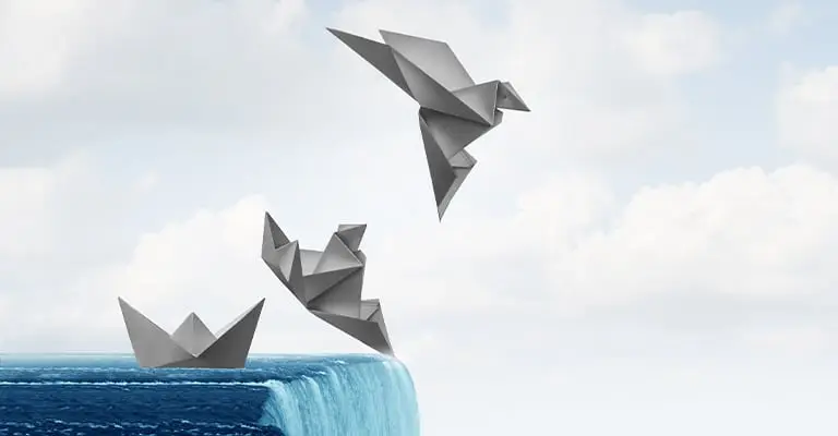 A paper boat approaches the edge of a waterfall as two origami birds rise into the cloudy sky. The transformation from boat to flight represents taking risks and adapting during early career advancement.