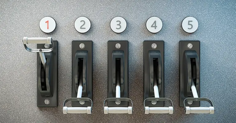 Alt text: Five black control levers are arranged beneath circular labels marked “1” through “5” on a textured metal panel. The adjustable settings represent the step by step controls involved in optimizing your social media strategy.
