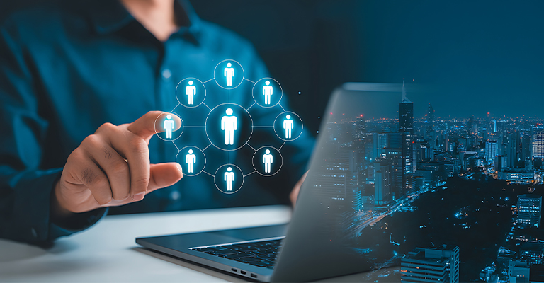 A person uses a laptop while selecting a digital network icon showing connected professional profiles against a city skyline at night. The image represents building professional connections and expanding career opportunities through LinkedIn for internships and networking.